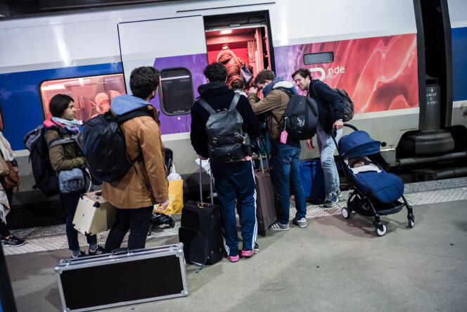Gare de Montparnasse, à Paris, des passagers montent dans un TGV complet en direction de Bordeaux, le 16 mars 2020.
