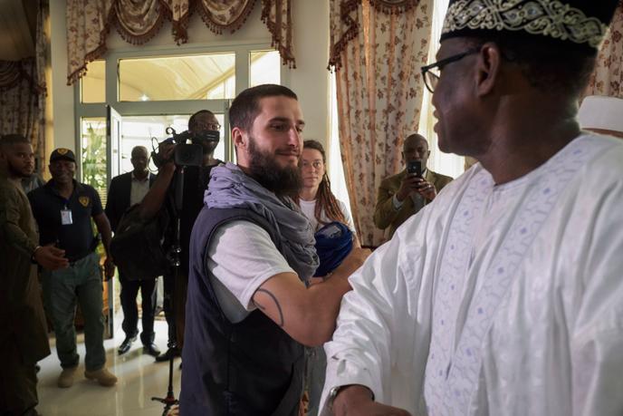 Luca Tacchetto et Edith Blais (en arrière-plan) sont accueillis par des officiels à leur arrivée à l’aéroport de Bamako, au Mali, le 14 mars 2020.