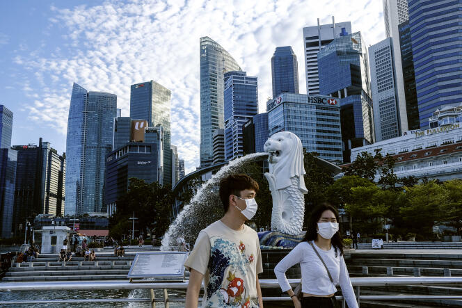 Devant la statue Merlion à Singapour, le 14 mars.
