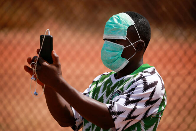 Un supporteur enregistre avec son téléphone l’un des derniers matchs de football autorisés, à Abuja, au Nigeria, le 5 mars 2020.