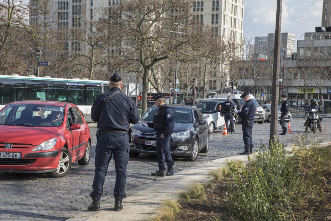 Des policiers contrôlent les documents nécessaires aux déplacements pendant le confinement, place d’Italie, à Paris, le 18 mars.