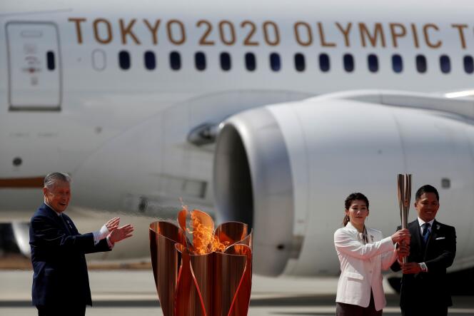 Les anciens champions olympiques Saori Yoshida et Tadahiro Nomura (à droite) ont allumé le chaudron olympique, aux cotés de Yoshiro Mori, président de Tokyo 2020, vendredi 20 mars sur le tarmac de l’aéroport d’Higashimatsushima.