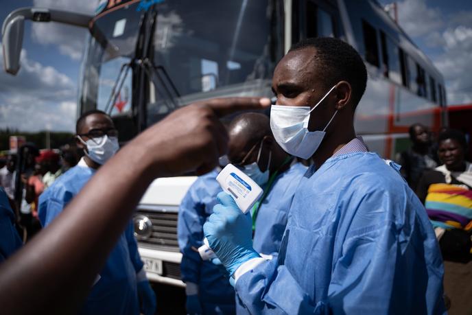 Un membre du Rwanda Biomedical Center (RBC) contrôle les passagers d’une gare pour freiner la propagation du coronavirus, à Kigali, le 22 mars.