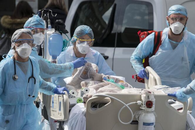 Le personnel médical emmène un patient vers un hélicoptère médical, à l’hôpital Emile-Muller à Mulhouse (Haut-Rhin), le 22 mars.