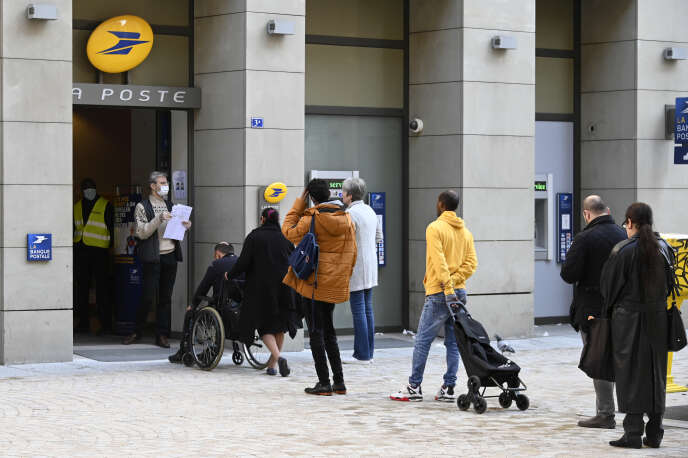 Des gens font la queue devant un bureau de La Poste, à Strasbourg, le 17 mars.