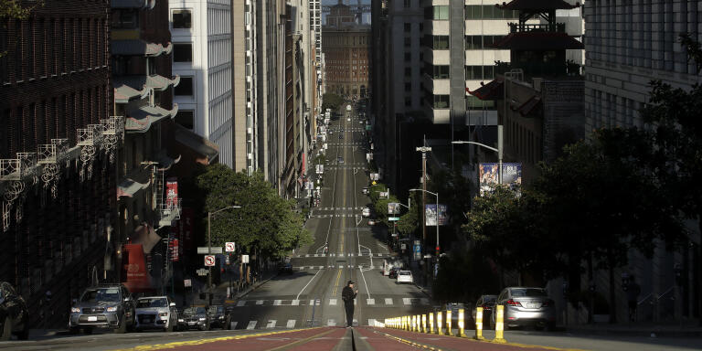 A man stands in the middle of a cable car tracks on a near empty California Street in San Francisco, Saturday, March 21, 2020. Some 40 million Californians are coping with their first weekend under a statewide order requiring them to stay at home to help curb the spread of the coronavirus(AP Photo/Jeff Chiu)