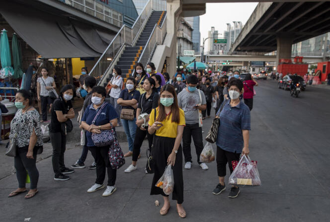 Des voyageurs attendent leur train à Bangkok, Thaïlande, le 24 mars.