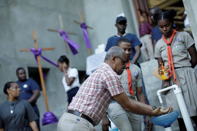 A man washes his hands outside a church on March 15 in Port-au-Prince.