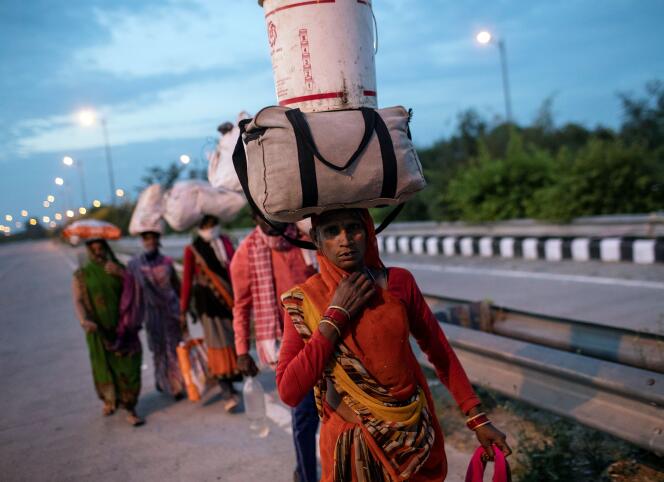 Une travailleuse migrante porte ses affaires sur la route de New Delhi à son village, le 26 mars.