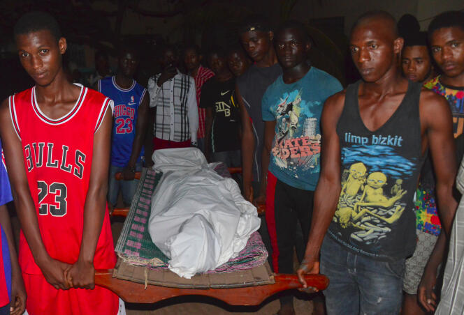 Des proches portent le corps d’un homme décédé lors d’affrontements entre la police et des manifestants à Conakry, le 22 mars 2020.