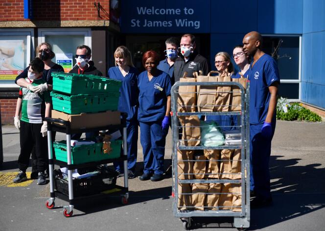 Infirmiers, médecins et volontaires reçoivent des repas pour les patients, à l’hôpital St Georges à Londres, le 23 mars.