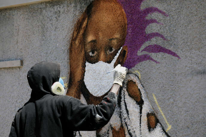 Serigne Boye alias « Zeus », un graffeur de l’équipe RBS, travaille sur sa peinture murale pour encourager les gens à se protéger, à Dakar, le 25 mars 2020.