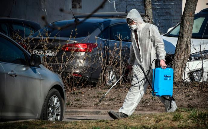 A city employee disinfects the street outside a block of buildings to prevent the spread of the coronavirus in Moscow on March 28.