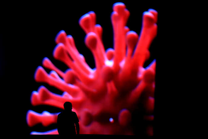 Un homme passe devant un écran géant pendant l’épidémie de Coronavirus, à Brasilia (Brésil), le 24 mars.
