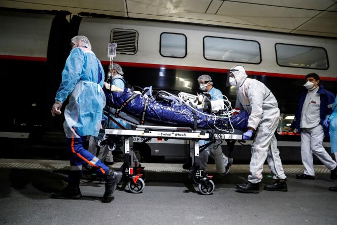 Du personnel médical embarque un patient atteint du Covid-19 à la gare d’Austerlitz, à Paris, le 1er avril.