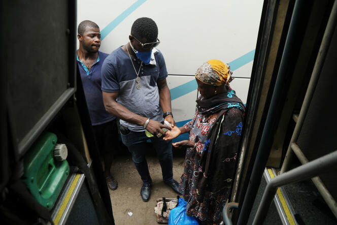Désinfection des mains avant de monter dans un bus, à Abidjan, le 24 mars 2020.