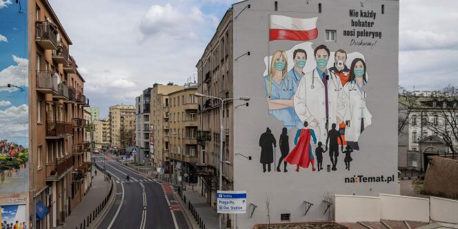 Une peinture murale rend hommage aux médecins et aide soignants luttant contre l’épidémie du COVID-19, à Varsovie, en Pologne, le 2 avril 2020.