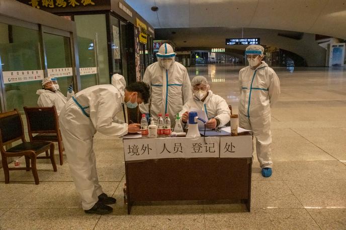 Une équipe du service d’enregistrement des passagers arrivant en gare de Wuhan. Leur température est prise, l’historique de leurs voyages récents analysés via une application téléphonique, ils sont ensuite dirigés vers le service d’acueil de leur district. Wuhan (Hubei), le 3 avril