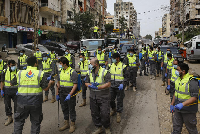 Des membres de la Société islamique de la santé, une branche du mouvement pro-iranien Hezbollah, se préparent à pulvériser du désinfectant  contre l’épidémie due au coronavirus, dans une banlieue sud de Beyrouth, au Liban, le 27 mars.