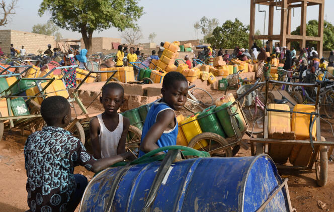 Des enfants patientent pour une distribution d’eau, à Taabtenga, quartier de Ouagadougou, la capitale du Burkina Faso, le 3 avril 2020.