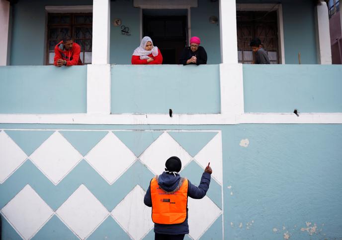 Un agent de santé parle à des habitants confinés au Cap, en Afrique du Sud, le 7 avril 2020.