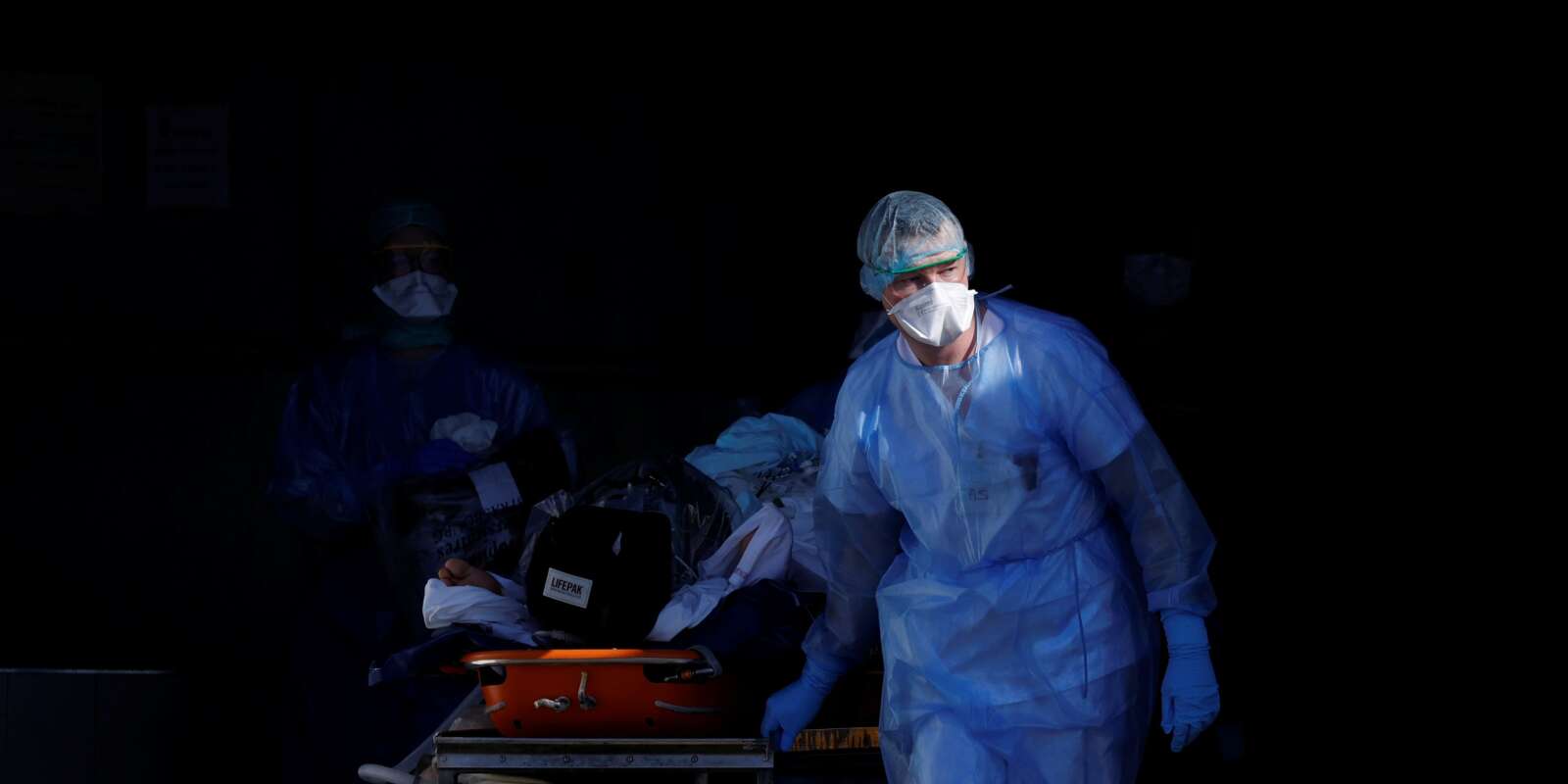 A patient infected with coronavirus is carried on a stretcher by a French rescue team before being transferred by a helicopter of the civil security (Securite Civile) from Strasbourg university hospital to Pforzheim in Germany as the spread of the coronavirus disease (COVID-19) continues in France, March 24, 2020. Picture taken March 24, 2020. REUTERS/Christian Hartmann