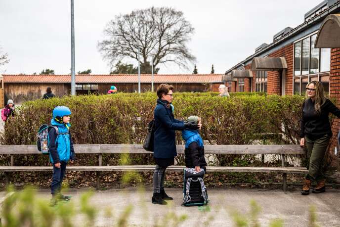 Des parents et leurs enfants font la queue pour entrer dans leur école, le 15 avril à Gladsaxe (Danemark).