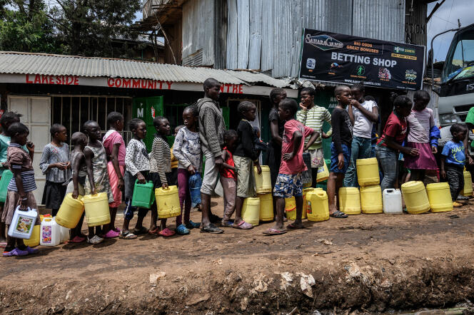 Des enfants font la queue pour remplir leur jerrican dans le bidonville de Kibera, à Nairobi, le 7 avril 2020. Le président kéyan, Uhuru Kenyatta, a annoncé la distribution gratuite d’eau aux plus défavorisés pour freiner la propagation du coronavirus.