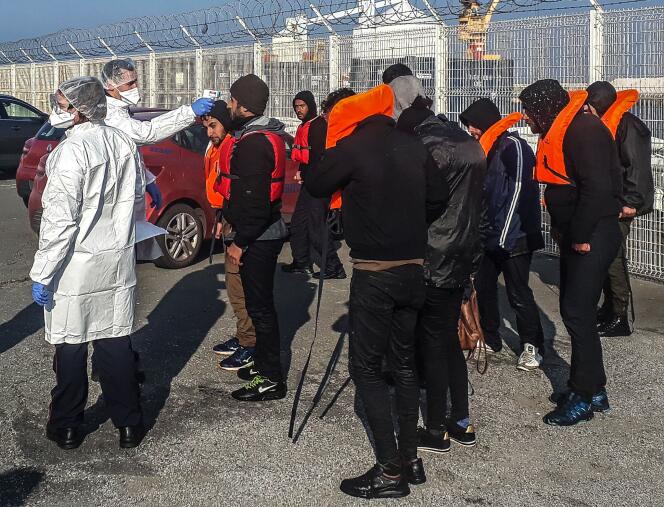 Un pompier prend la température de migrants récupérés au large de Calais alors qu’ils tentaient la traverée vers la Grande-Bretagne, le 17 avril.