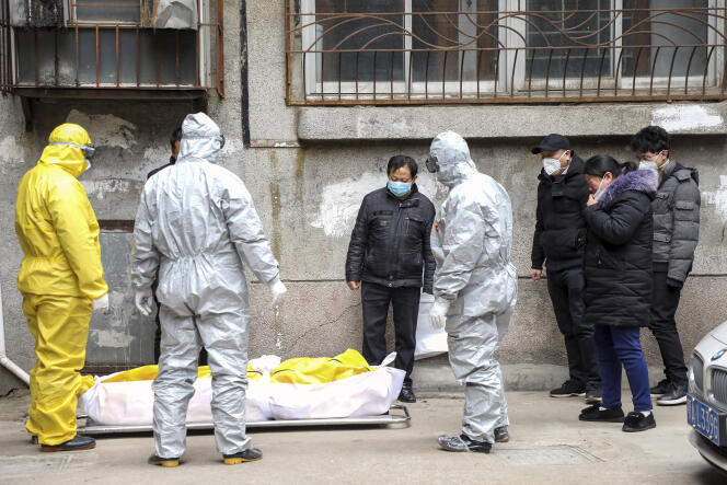 Des employés funéraires transportent le corps d’une personne suspectée d’être morte du Covid-19, le 1er février à Wuhan, en Chine.