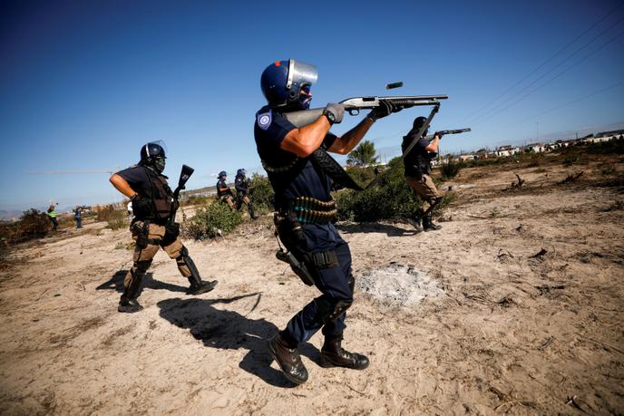 Des policiers sud-africains tentent de fairee appliquer le confinement dans le township de Khayelitsha, au Cap, le 21 avril 2020.