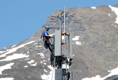 FILE PHOTO: A technician is roped up as he installs 5G antennas of Swiss telecom operator Swisscom on a mast in the mountain resort of Lenzerheide, Switzerland June 13, 2019. REUTERS/Arnd Wiegmann/File Photo