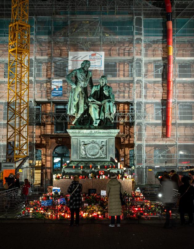 Hanau (Hesse), le 22 février. Fleurs, bougies et photos entourent la statue des frères Grimm, originaires de la ville. Des passants ont ainsi rendu hommage aux victimes du massacre perpétué le 19 février par un extrémiste de droite allemand de 43 ans.