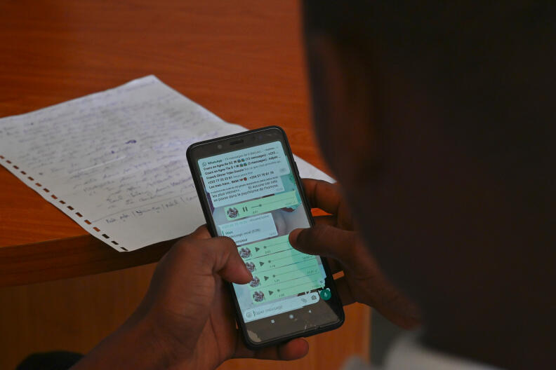 A teacher teaches and shares lessons with students via Whatsapp in the district of Port Bouet in Abidjan on April 21, 2020. - A group of private college teachers teaches free lessons with students after the Ivorian Ministry of National Education initiated on April 9, 2020, teaching on television for primary and secondary school children following the closure of schools in the country following the outbreak of the COVID-19 coronavirus. (Photo by ISSOUF SANOGO / AFP)