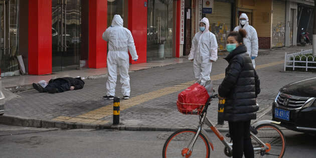 Une équipe de médecins s’occupe d’un vieil homme décédé dans la rue, à côté d’un hôpital, à Wuhan, le 30 janvier.