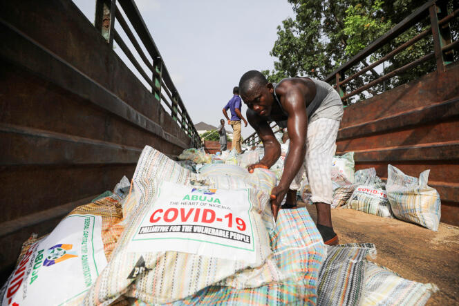 Des hommes chargent des sacs de riz de l’aide alimentaire pour personnes vulnérables pendant la pandémie de Covid-19, à Abuja, au Nigeria, le 17 avril 2020.