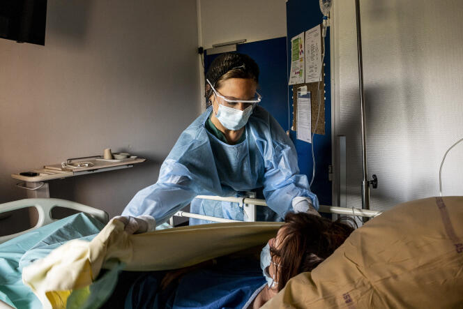 Une soignante accueille une patiente amenée par le SAMU dans l’unité Covid-3 de l’hôpital Beaujon, à Clichy.