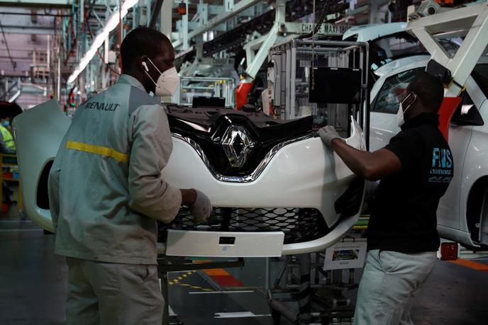 Des employés portant des masques de protection travaillent sur la ligne de montage de la Renault Zoé, dans l’usine de Flins (Yvelines), mercredi 6 mai.