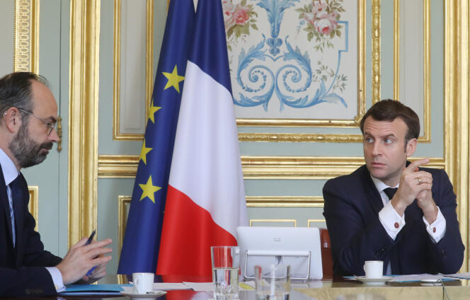 Edouard Philippe et Emmanuel Macron lors d’une  vidéoconférence au palais de l’Elysée à Paris, le 19 mars.