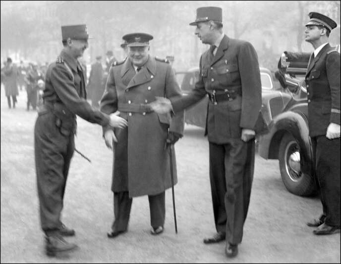Le général Pierre Koenig et le général Charles de Gaulle se serrent la main en présence du premier ministre britannique, Winston Churchill, lors des cérémonies du 11 novembre 1944, à l'Arc de Triomphe, à Paris.
