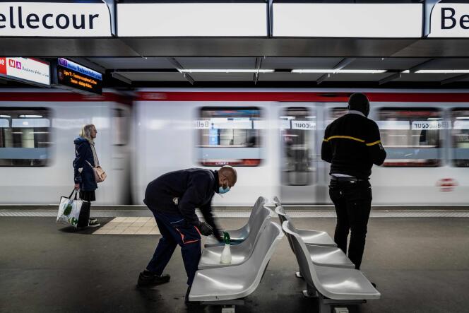Un employé portant des gants et un masque protecteur désinfecte les sièges d’une station de métro, à Lyon, le 7 mai.