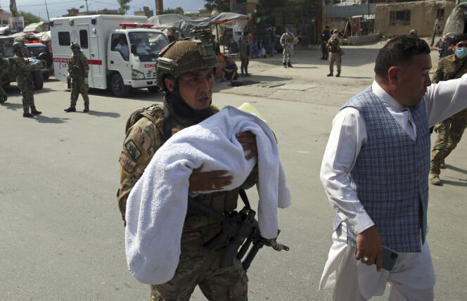 Un soldat des forces afghanes évacue un bébé à proximité de l’hôpital de Kaboul visé par une attaque, mardi 12 mai.