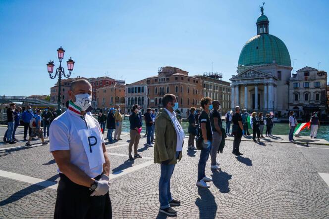 Des commerçants réclament la réouverture des commerces lors d’un flashmob près de la gare de Venise-Santa-Lucia, le 4 mai.