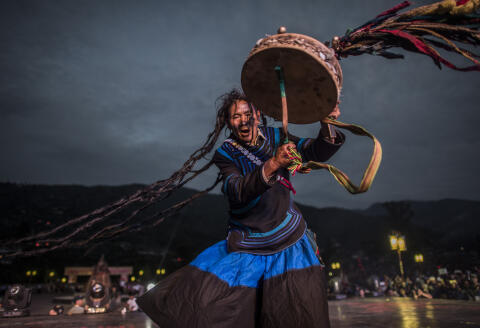A shaman, dressed with the traditional Yi costume, performs at the Torch Festival, in Xichang, China's Sichuan province on July 27, 2016. - As a result of fast urbanisation in the rural area of China Like Lienchang prefecture, the traditional costume is fading away for the Yi people in daily life. (Photo by FRED DUFOUR / AFP)