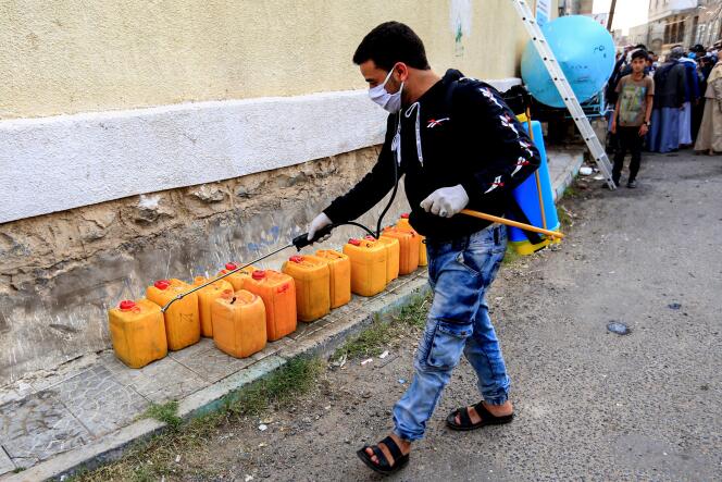 Un volontaire stérilise des jerricans d’eau dans la rue. à Sanaa, le 14 mai.