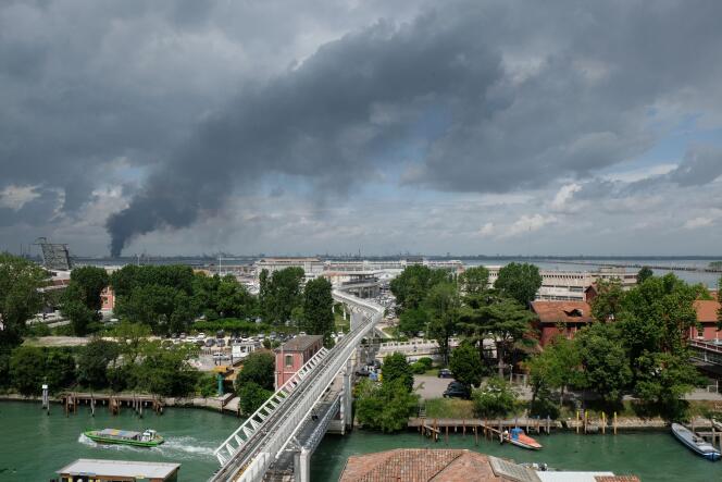 Une épaisse fumée noire s’échappe de l’usine chimique où s’est déclaré un incendie, vendredi 15 mai, vu de Venise.
