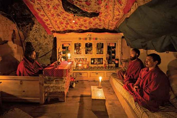 A l’intérieur de la grotte, les disciples et le maître méditent à la lueur de la bougie.