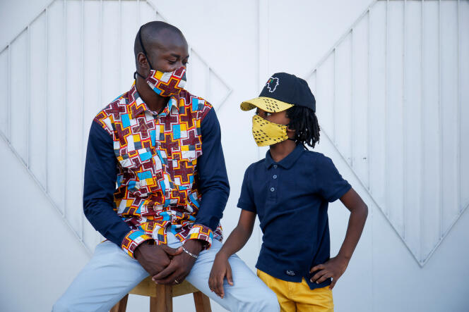 Arthur Bella N’guessan, un designer ivoirien, et un jeune mannequin posent alors qu’ils portent des masques protecteurs aux couleurs assorties à leurs vêtements, à Abidjan, le 13 mai 2020.
