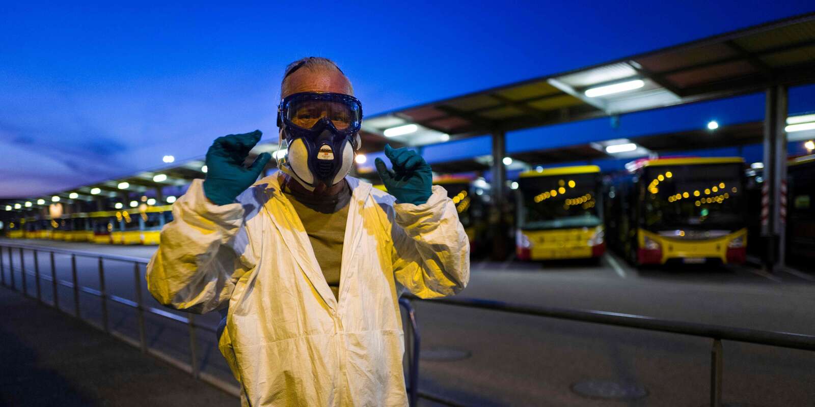 A worker puts on a protective suit and mask prior to disinfect a bus at the Solea transport depot in Mulhouse, eastern France, on May 20, 2020, as France eases lockdown measures taken to curb the spread of the COVID-19 pandemic, caused by the novel coronavirus. / AFP / SEBASTIEN BOZON