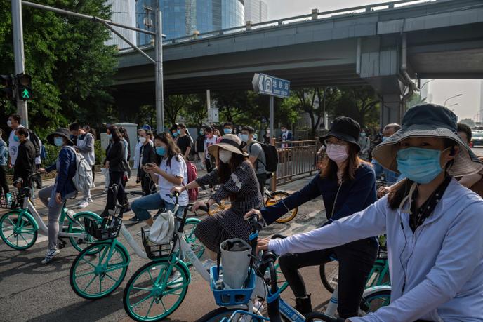 Des hordes de cyclistes masqués à Pékin, vendredi 22 mai.